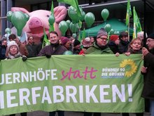 Bündnisgrüne Menschen halten ein Transparent hoch mit der Aufschrift "Bauernhöfe statt Tierfabriken". Das Foto ist auf der Demonstration "Wir haben es satt!" am 21. Januar 2017 in Berlin aufgenommen. Mit dabei sind die Landesvorsitzenden Petra Budke und Clemens Rostock, Thomas Dyhr aus Barnim und Axel Vogel, der Fraktionsvorsitzende von BÜNDNIS 90/DIE GRÜNEN.
