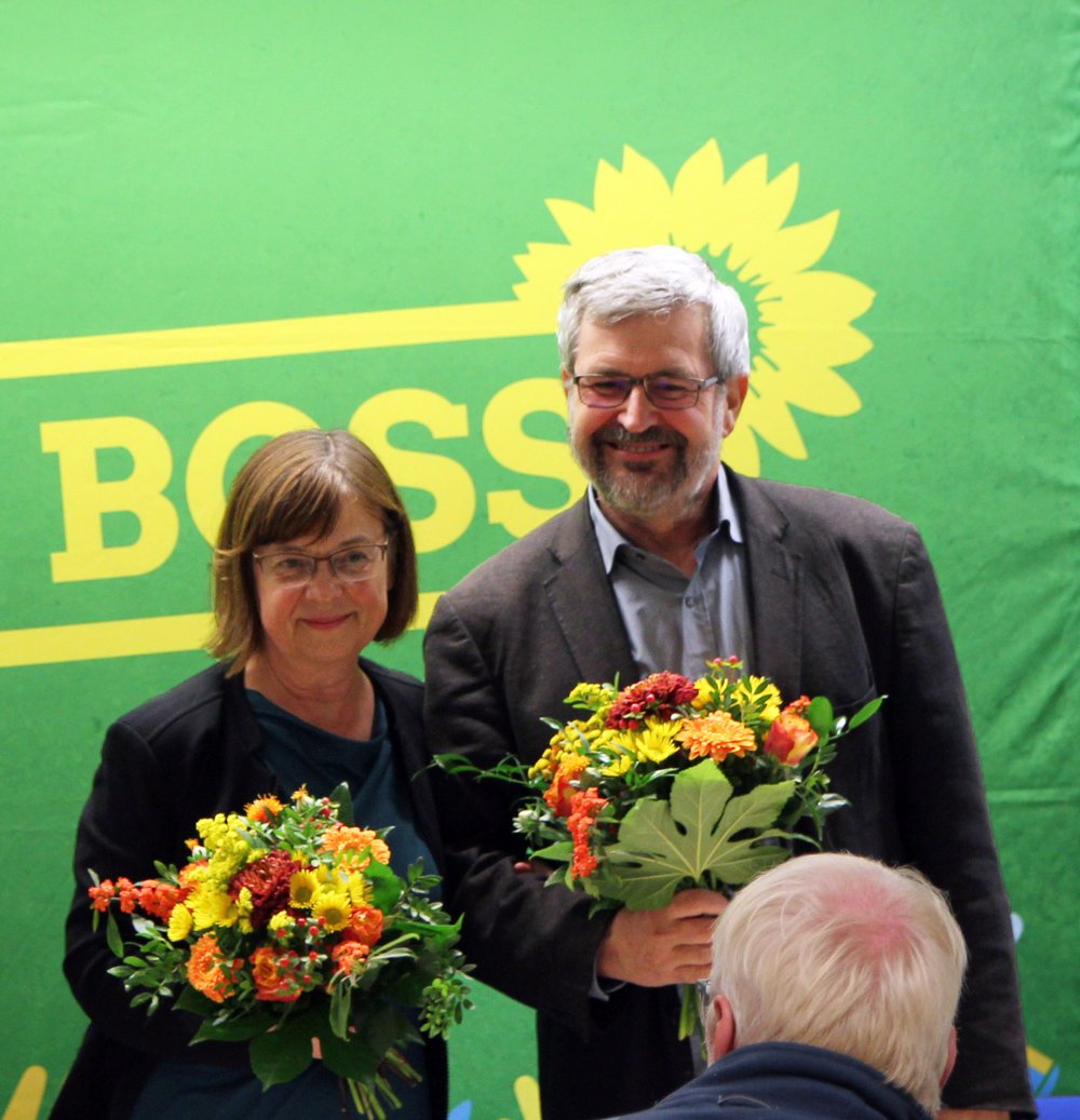 Vor der grünen Leinwand "Basis ist Boss" stehen die zwei Fraktionsvorsitzenden von BÜNDNIS 90/DIE GRÜNEN im Brandenburger Landtag, Ursula Nonnemacher und Axel Vogel. Beide haben einen Blumenstrauß in der Hand, den sie von den beiden Landesvorsitzenden Petra Budke und Clemens Rostock überreicht bekommen. Sie freuen sich beide über ihre Wahl mit 92,4 Prozent Zustimmung. Ernennen allerdings muss sie der Ministerpräsident.