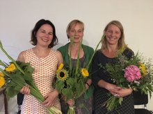 Die drei Frauen Annalena Baerbock, Petra Budke und Kathleen Kunath halten jeweils einen Strauß mit Sonnenblumen in ihrer Hand. Es ist Sommer, sie haben Kleider an und lächeln froh in die Kamera. Denn soeben fand das gute Gespräch mit der Willkommensinitiative Falkensee statt, die viel für die Integration der Geflüchteten leistet.